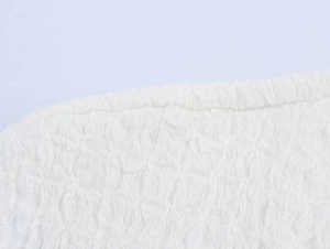 Detailed macro view of high-quality white textured fabric with 3D bubble pleat patterns