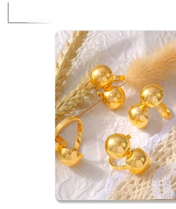 Detailed view of three 18k gold plated double bead rings on decorative background