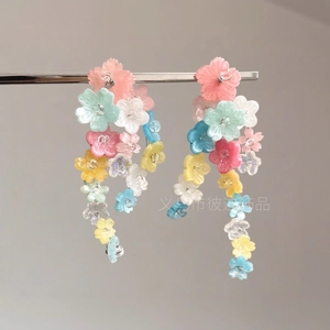 Détail de boucles d'oreilles fleurs colorées avec pétales en acrylique sur support argenté