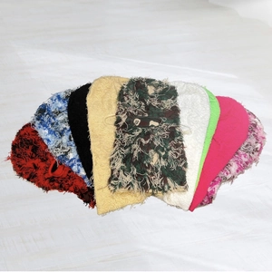 Flat lay display of colorful distressed knit balaclavas in camouflage and solid colors