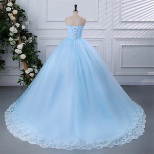 Detail of light blue strapless gown featuring lace trim and lace-up back design