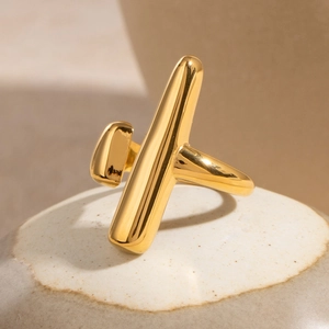 Macro detail of minimalist gold geometric ring featuring polished vertical bar and cylinder