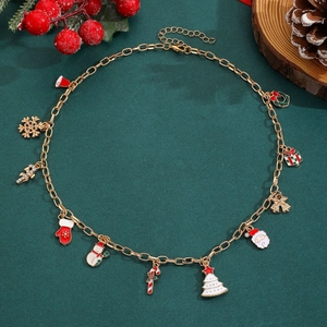 Détail du collier de Noël avec breloques en émail coloré sur fond vert foncé
