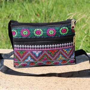 Ethnic style black crossbody bag with vibrant cross-stitch floral and geometric patterns