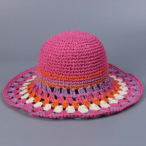 Detail of colorful bohemian crochet patterns on a handmade wide brim straw sun hat