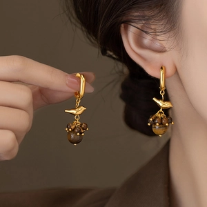 18k gold plated bird earrings with tiger eye stone tassels shown on model