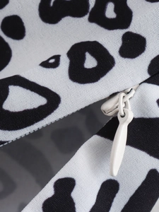 Detailopname van zwart-witte luipaardprint stof en witte onzichtbare ritssluiting