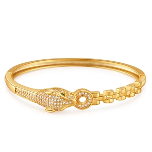 Gold leopard head open bangle with sparkling stones and green gem eyes on white background