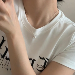 Detailed view of an S925 silver necklace with a heart knot pendant on a model's neck