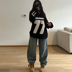 Oversized black crewneck sweatshirt with BADNM 77 print and loose blue jeans