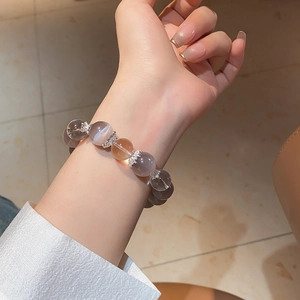 Macro detail of natural cat eye stone beaded bracelet with ornate vintage metal accents