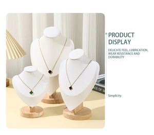 Three solid wood necklace display busts with white faux leather finish in natural light