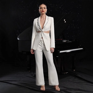 Detailed view of white tailored suit featuring hollow waist design and sparkling rhinestones