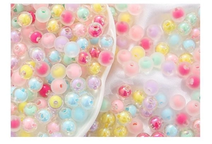 Macro shot of colorful acrylic beads in a heart-shaped tray for DIY jewelry making