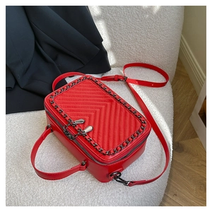Dettaglio della borsa a tracolla trapuntata rossa in PU con catena e cinturino eleganti