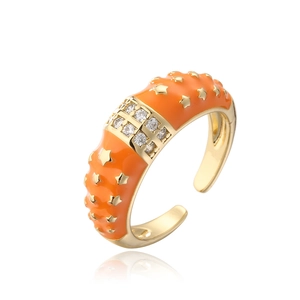 Detail of orange enamel ring with gold stars and sparkling white zircon stones