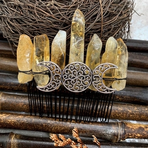 Detail of handmade yellow crystal hair comb with crescent moon and metallic floral design