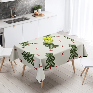 Beige Christmas tablecloth with green trees and red cross patterns in a modern home setting