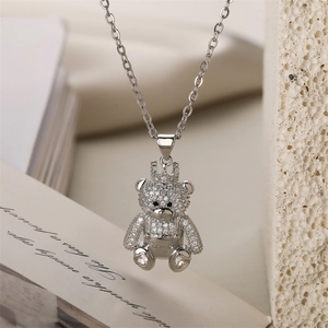 Macro view of a silver teddy bear pendant with a crown and shimmering pavé zircons