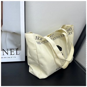 Detailed close-up showing canvas texture and printed anniversary lettering on a tote bag