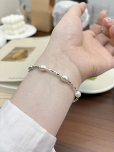 Close-up of a s925 sterling silver bracelet with natural freshwater pearls on a woman wrist