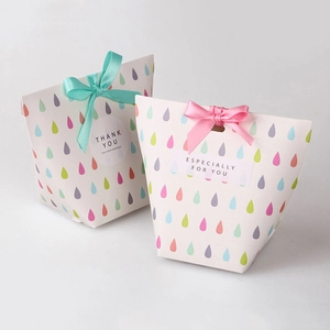 Detail of colorful waterdrop print gift boxes with elegant ribbon bows and labels