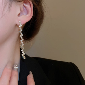 Elegant long wave zircon tassel earrings worn by a model in a luxury black suit