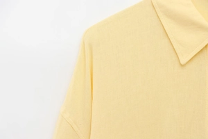 Detailed view of pale yellow cotton linen shirt collar and shoulder stitching texture