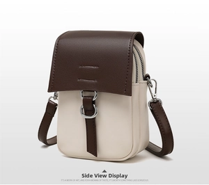 Detail view of mini crossbody bag featuring dual zippers and silver ring ornament