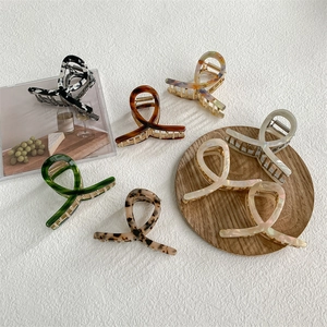 Set of 7 elegant acetate shark hair clips in marble, amber, and leopard patterns