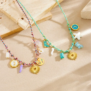 Bohemian braided cord necklace set with gold moon and Good Luck charms on sand