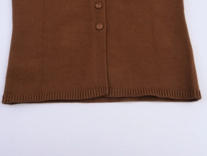 Macro detail of dark brown knit top featuring ribbed hem and matching button closure