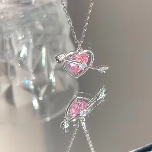 Macro view of pink heart cupid pendant necklace with sparkling diamonds on silver chain