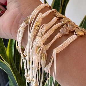 Detailweergave van Boheemse geweven armbanden met gouden hart- en LOVE-bedeltjes