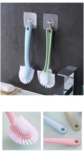Close-up of double-headed shoe brush with stiff bristles and a floral wall hook