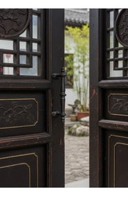 Close-up of vintage black iron door handle installed on carved solid wood furniture