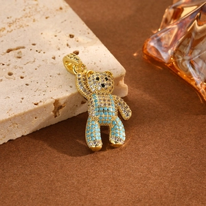 Detailed close-up of a gold-plated bear pendant with blue and white zircon micro-pave