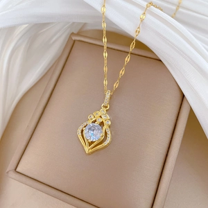 Detail of tear-drop crystal pendant with sparkling zircons on gold plated chain necklace