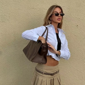 Mode-Streetstyle mit weißem Cropped-Hemd, Faltenrock und dunkelbrauner Leder-Einkaufstasche