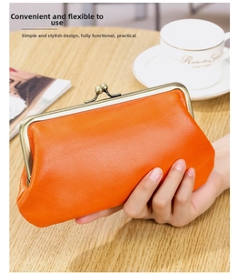 Close-up of orange litchi grain leather clutch bag with golden vintage metal clasp