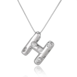 Macro shot of silver letter H pendant with micro-paved zircons on a classic box chain