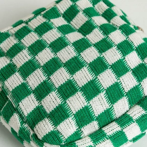 Detailed macro shot of premium thick knit texture on green and white checkered pouch
