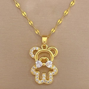 Detail of gold bow-knot bear pendant with sparkling white zircons on a delicate chain