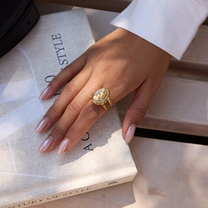 Detail of gold oval ring with relief portrait and white zircon stones on book