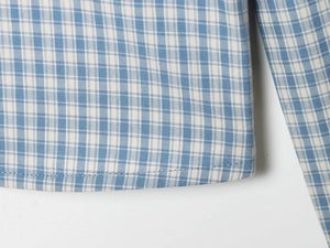 Detailed macro view of the blue and white checkered cotton fabric with precise stitching