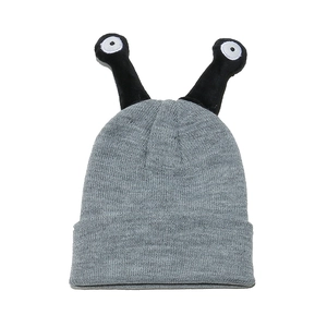 Detail of grey knitted monster hat showing top antennae with embroidered eyeball decor