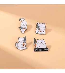 Macro detail of four cute white cat enamel pins with knives and be nice slogan text