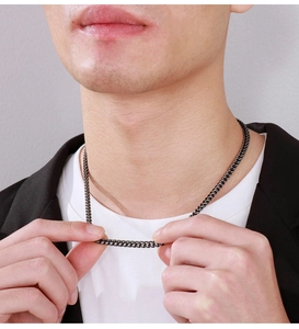 Close-up of a black stainless steel dragon bone chain necklace on a male model
