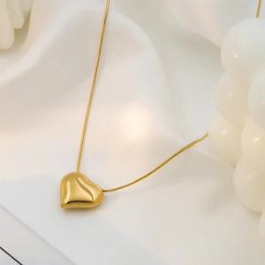 Minimalist 18k gold plated heart pendant necklace with sleek snake chain on white silk