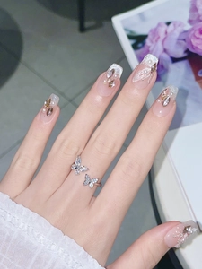 Detail of silver butterfly ring and crystal nails with pearls and glitter